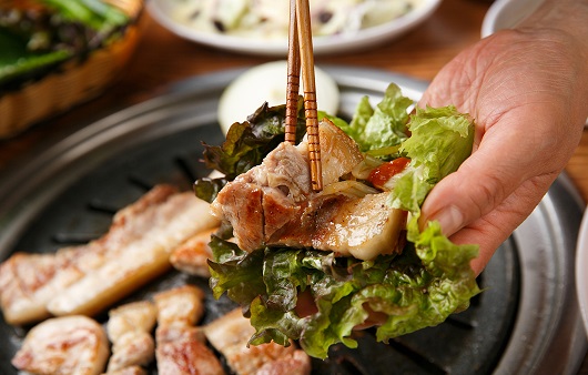 Một bàn tiệc Ssam với thịt nướng và rau xanh